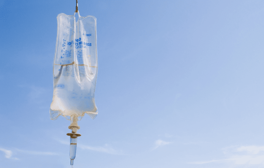 IV bag against a clear blue sky.